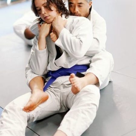 BJJ instructor applying rear choke technique on student during adult jiu-jitsu class in Hanover MD